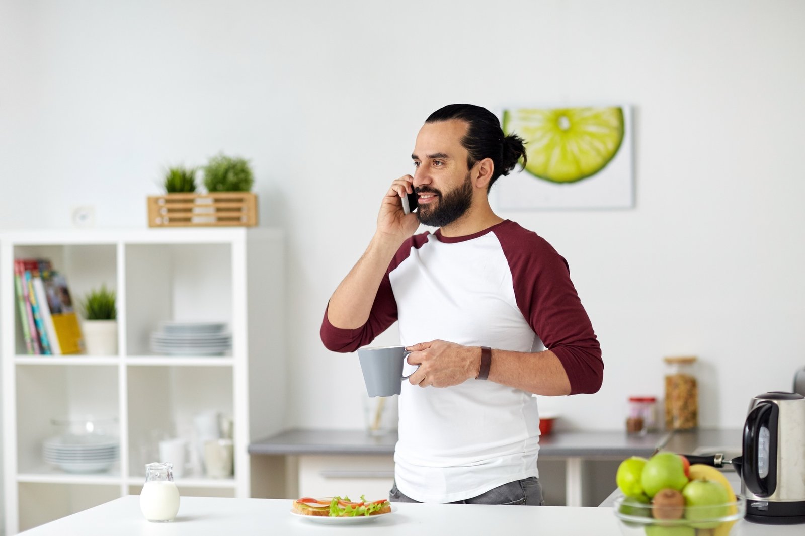 man calling on smartphone and eating at home